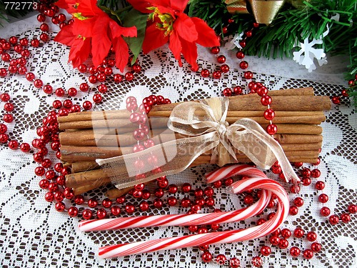 Image of Christmas candy canes, cinnamon sticks and poinsettias