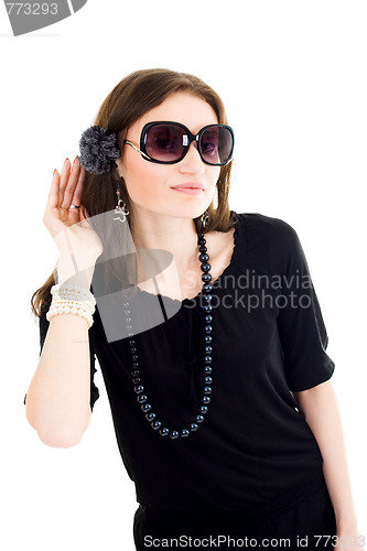 Image of Woman in black dress and sunglasses listen