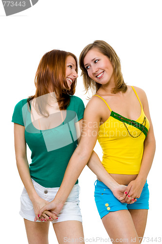 Image of Two happy young women friends walk together