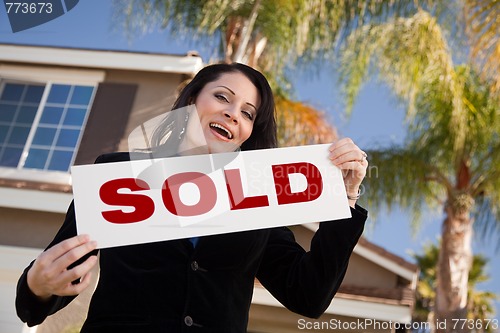 Image of Attractive Hispanic Woman Holding Sold Sign In Front of House