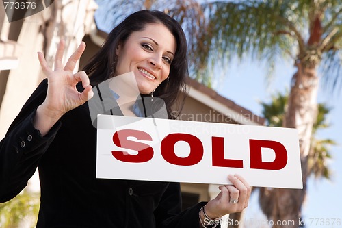 Image of Attractive Hispanic Woman Holding Sold Sign In Front of House