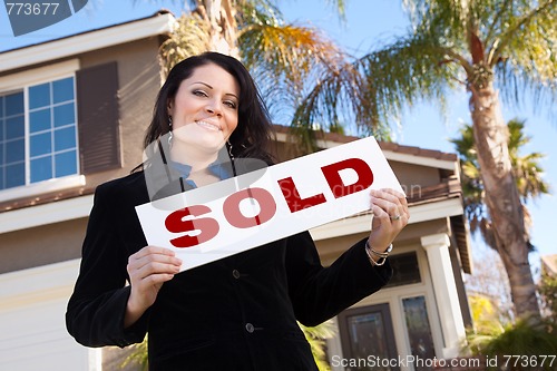 Image of Attractive Hispanic Woman Holding Sold Sign In Front of House