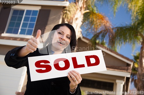 Image of Attractive Hispanic Woman Holding Sold Sign In Front of House