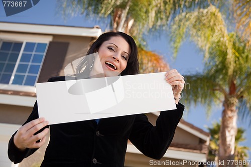 Image of Attractive Hispanic Woman Holding Blank Sign in Front of House