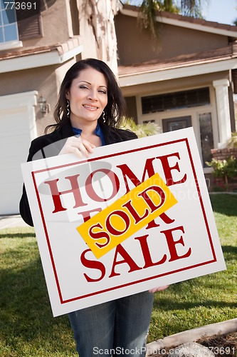 Image of Woman Holding Sold Real Estate Sign In Front of House
