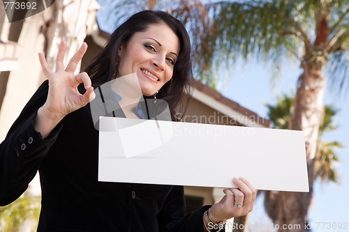 Image of Attractive Hispanic Woman Holding Blank Sign in Front of House