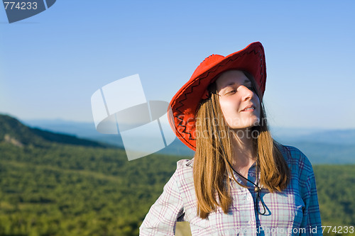 Image of Young woman in cowboy looking hat