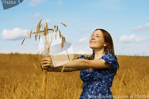 Image of woman holding bundle of wheat ears 