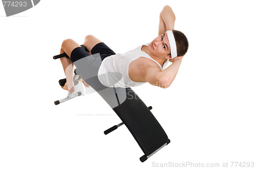 Image of Young man exercise on bench working on abdominal muscles