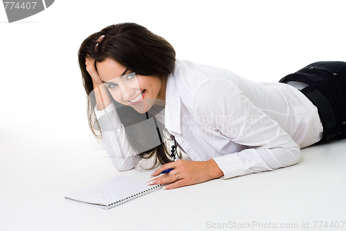 Image of Woman laying on the floor with note book smiling and laughing