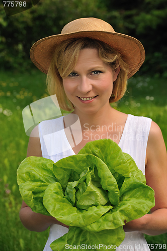 Image of Young woman holding fresh lettuce