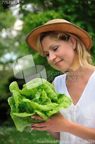 Image of Young woman holding fresh lettuce