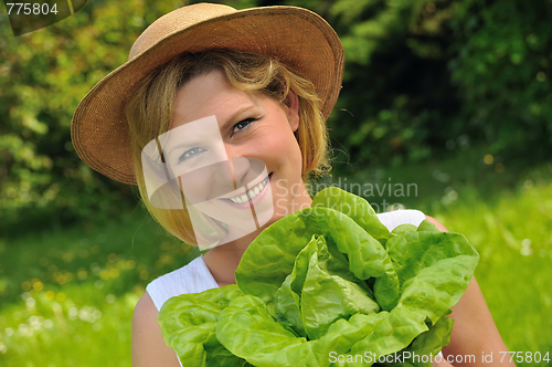 Image of Young woman holding fresh lettuce