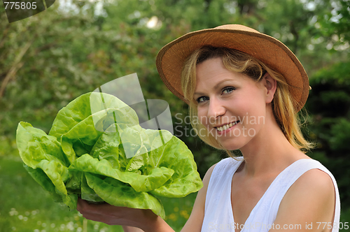 Image of Young woman holding fresh lettuce