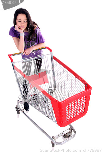 Image of Unhappy girl with shopping cart 