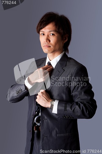 Image of Successful Asian business man fixing tie