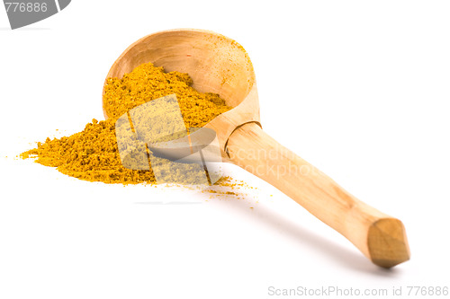 Image of yellow turmeric on wooden spoon