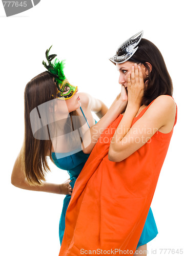 Image of Two surprised young women wearing mask at masquerade party