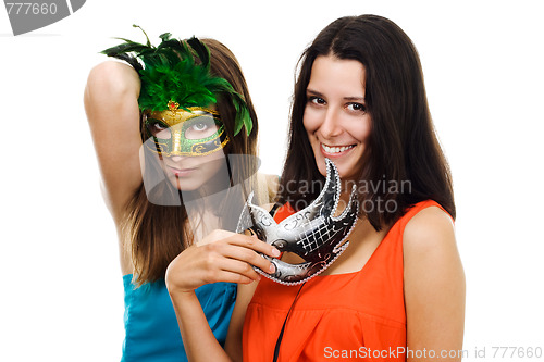 Image of Two young happy woman at party with italian masks