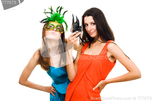 Image of Two women in masks and color dresses flirting