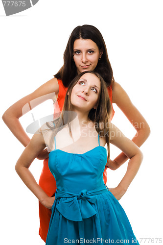 Image of Two young women stand together in vivid color dresses