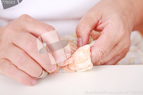 Image of Elderly woman sewing