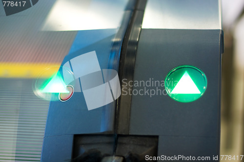 Image of green arrow sign on escalator