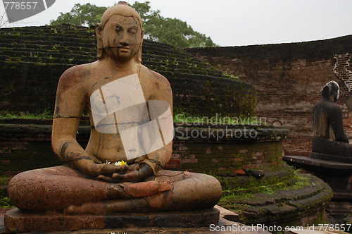 Image of Seated Buddha Statues In The Rain