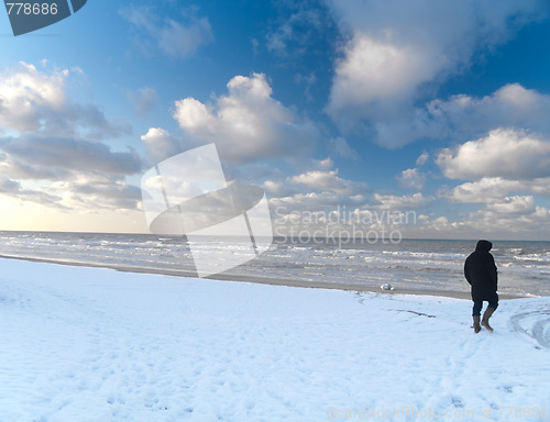 Image of Man walking in snowy beach