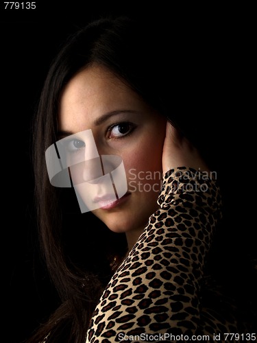 Image of Young brunette on black touching hair