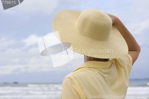 Image of Woman with hat on a beach