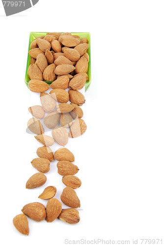 Image of Scattered almond nuts on a cup sliding down