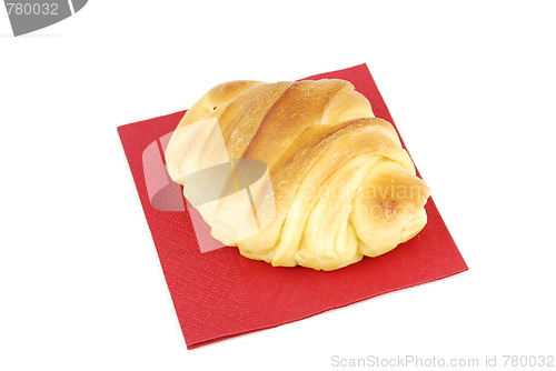 Image of One fresh croissant on a red napkin