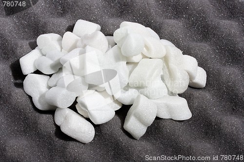 Image of Heap of white shipping foam on black sheet of wavy foam rubber 