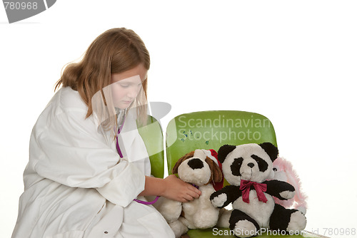 Image of girl playing doctor with her toys