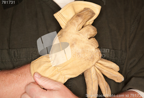 Image of Man Putting on Leather Construction Gloves