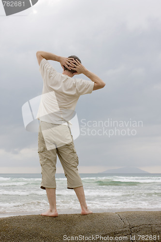 Image of Man relaxing on a rock at the sea