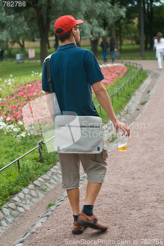 Image of young man walking with a beer