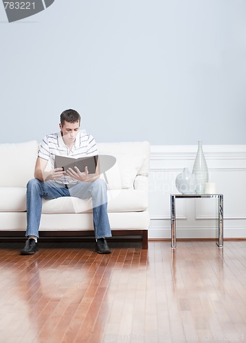 Image of Man Reading on Living Room Couch