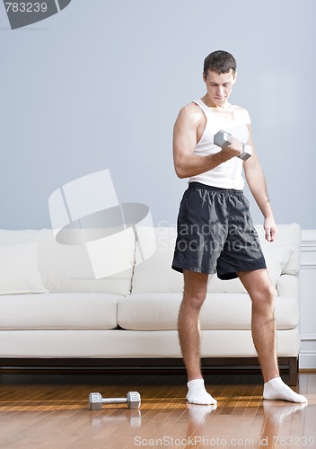 Image of Man Using Arm Weights in Living Room