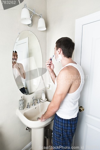 Image of Young Man in Bathroom Shaving