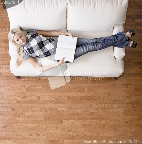 Image of Overhead View of Woman With Book on Couch