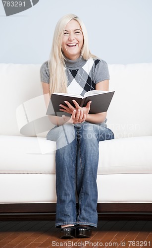 Image of Happy Woman Sitting on Couch With Book