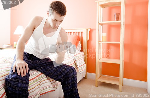 Image of Man Using Arm Weight in Bedroom