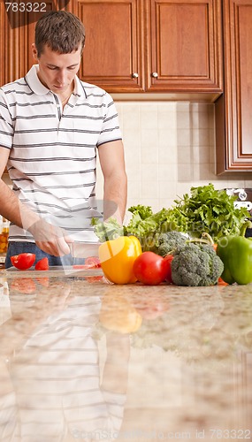 Image of Young Man Cutting Tomato