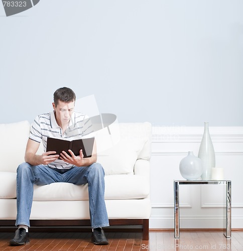 Image of Man Reading on Living Room Couch