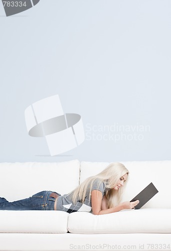 Image of Woman Reclining on Couch With Book