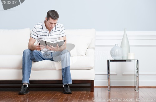 Image of Man Reading on Living Room Couch
