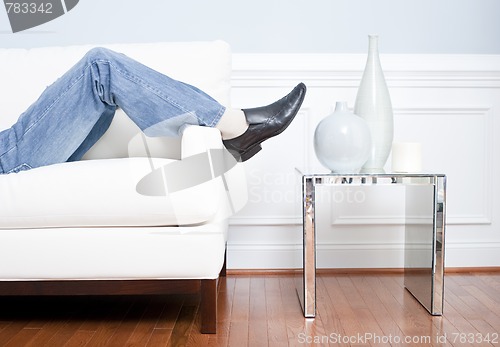 Image of Man's Legs Reclining on White Couch
