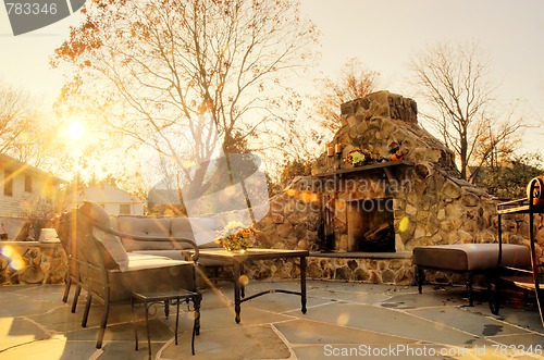 Image of Sunlit Patio With Stone Fireplace